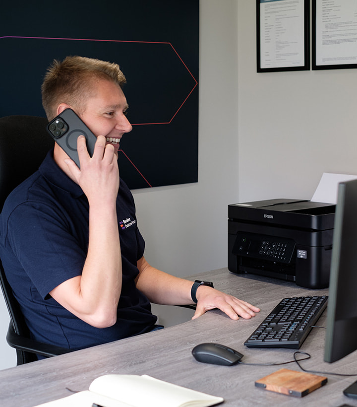 Man sitting at desk in an office, on the phone